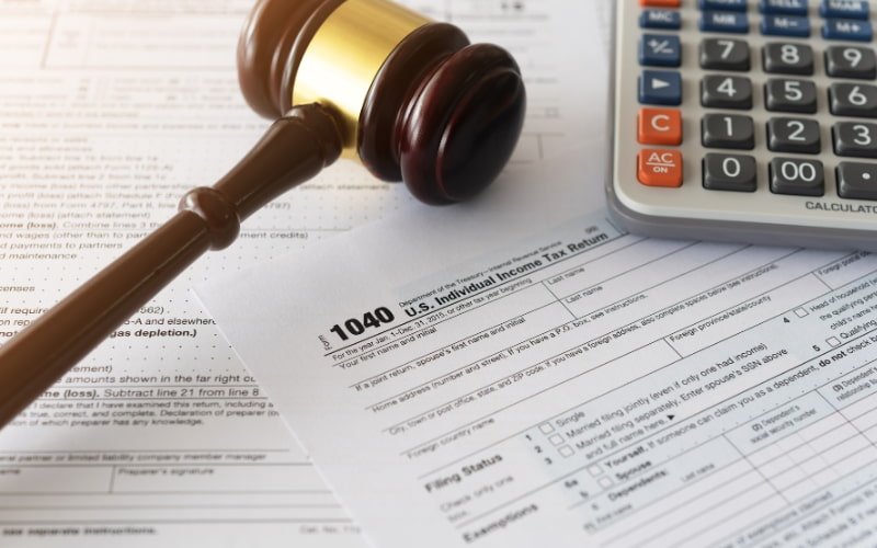 Profissionais analisando documentos fiscais e gráficos de planejamento tributário.