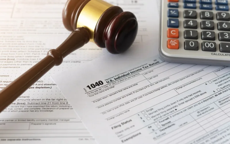 Profissionais analisando documentos fiscais e gráficos de planejamento tributário.
